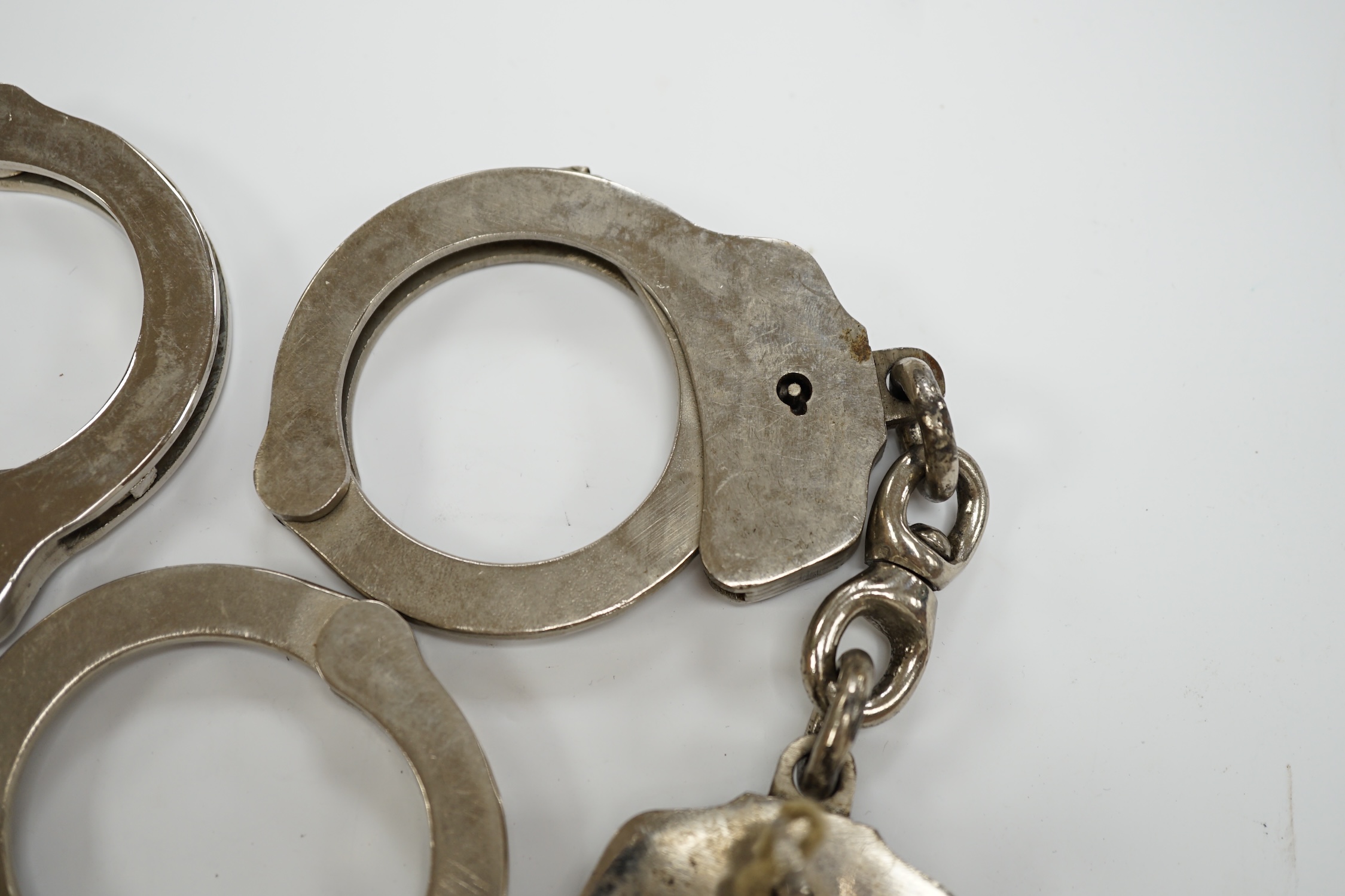 Three handcuffs, two with keys and two Metropolitan Police badges